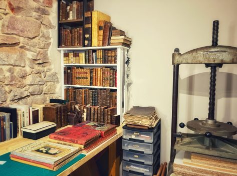 Atelier de reliure avec presse à percussion et livres anciens